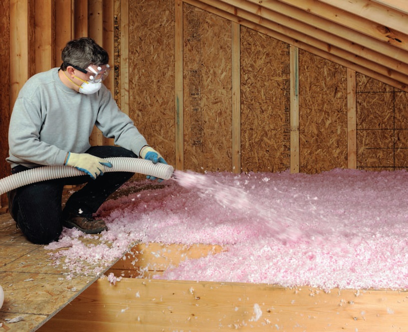 Technician installing clean new attic insulation